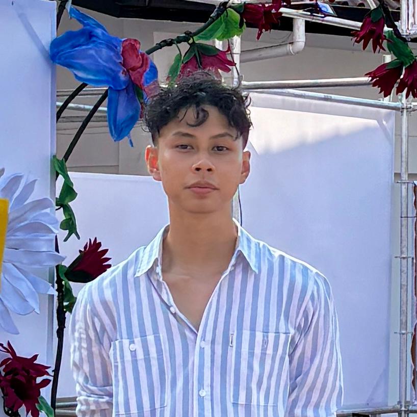 Self portrait at a florist booth, blue and red blooms above